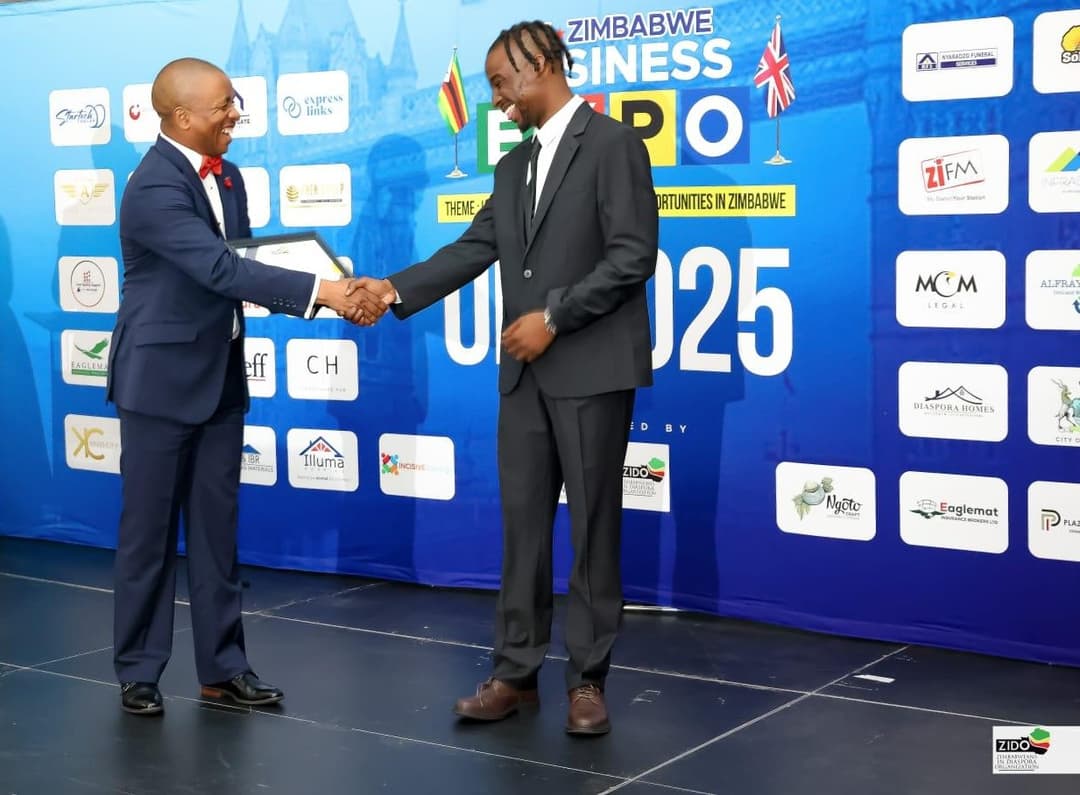 Emperor Roy handshake on stage at the UK-Zimbabwe Business Expo